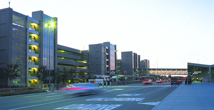 Modern airport terminal with vehicles and walkway