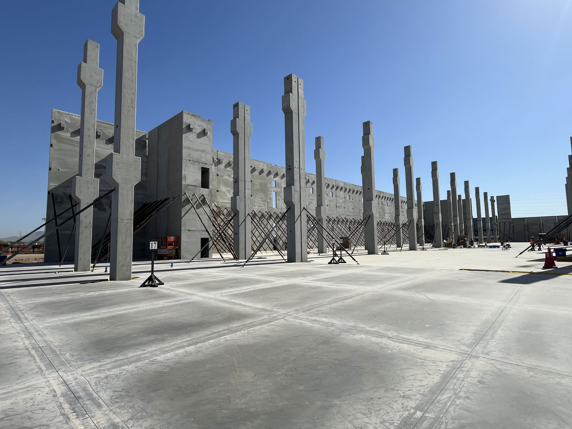 Construction site with concrete columns and wall panels.